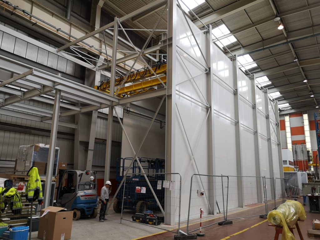 chantier d'une salle blanche industrielle, mise en place de panneaux sandwich sous une structure métallique